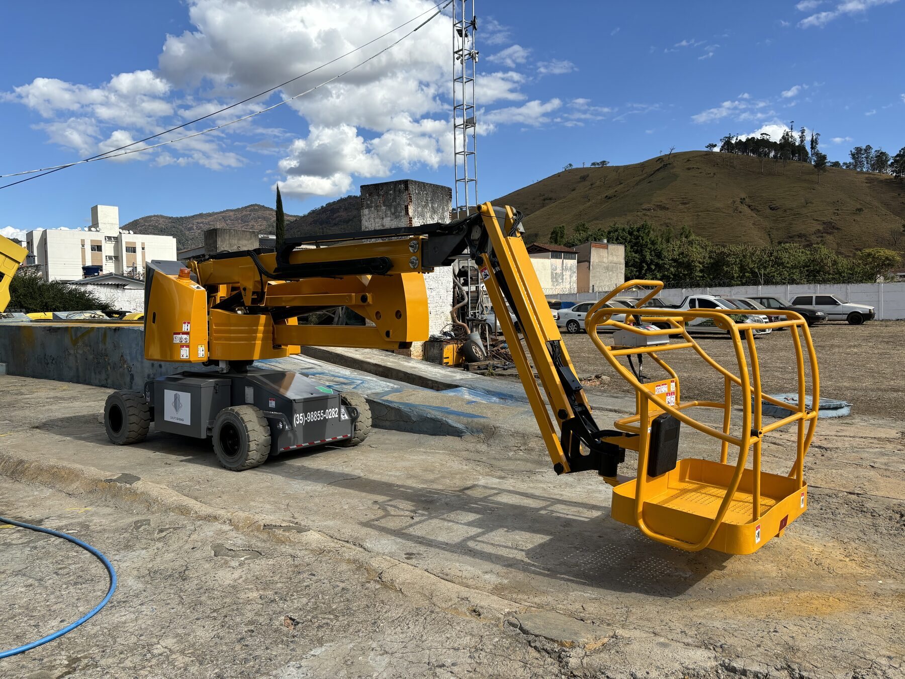 Plataforma articulada amarela em operação para trabalho em altura